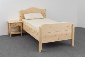 Einzelbett Farrenpoint aus Alpenzirbe, Kopfhaupt mit geschweiftem Bogen, Fußhaupt und Bettpfosten gerundet, Abb. optional: Zirbenholz-Nachtkästchen, ergonomisches ProNatura-Schlafsystem - Original Steiner Zirbenbett