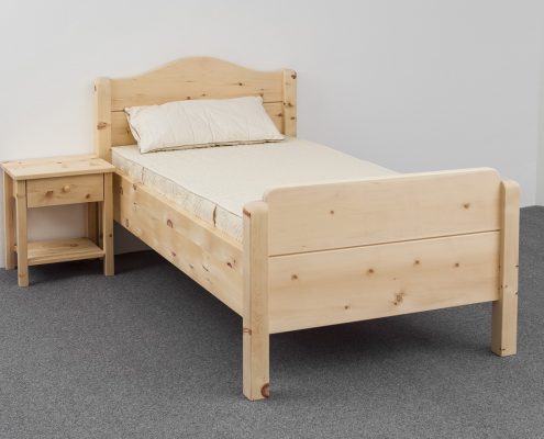 Einzelbett Farrenpoint aus Alpenzirbe, Kopfhaupt mit geschweiftem Bogen, Fußhaupt und Bettpfosten gerundet, Abb. optional: Zirbenholz-Nachtkästchen, ergonomisches ProNatura-Schlafsystem - Original Steiner Zirbenbett