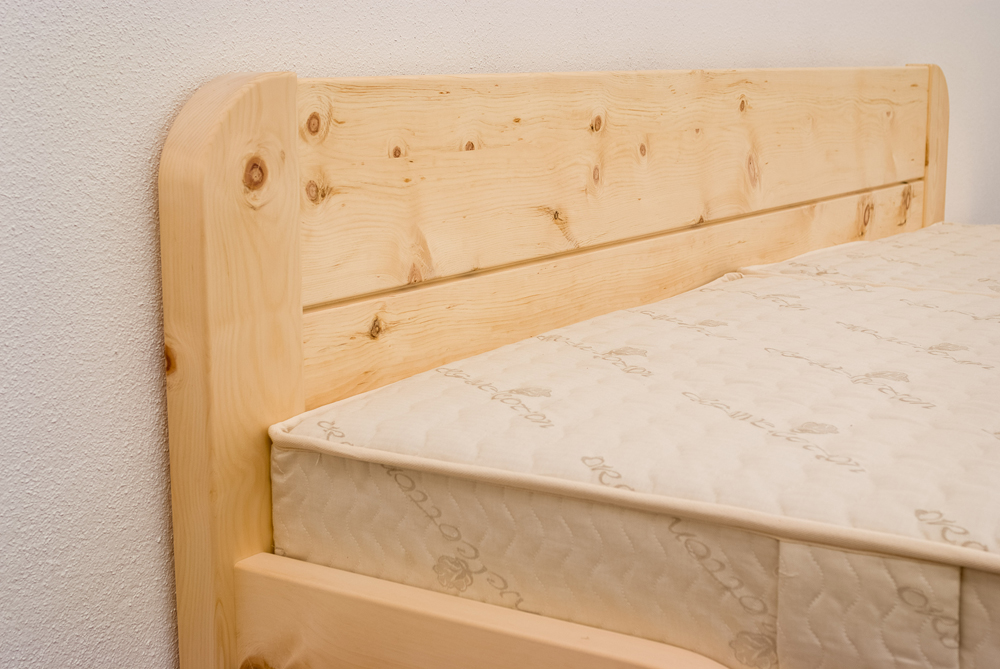 Abgerundete, nach oben verlängerte und ins Kopfhaupt integrierte Bettpfosten am Zirbenbett Kaiserblick - Original Steiner Zirbenbett