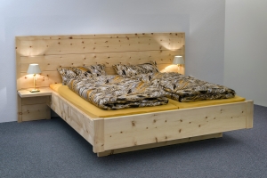 Abb.: Doppelbett Kranzhorn mit extra breitem und höherem Kopfhaupt, angesetzten Nachttischplatten und frei schwebendem Fußbereich - Original Steiner Zirbenbett