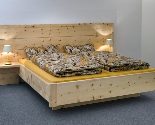 Abb.: Doppelbett Kranzhorn mit extra breitem und höherem Kopfhaupt, angesetzten Nachttischplatten und frei schwebendem Fußbereich - Original Steiner Zirbenbett
