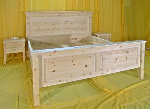 Doppelbett Schwarzenberg – traditionelles Zirbenbett, Variante mit Kopfhaupt in nomaler Höhe, Kopf- und Fußhaupt mit erhabenen Füllungen, der Aufsatz ist als Gesamtprofil gefertigt, Abb. mit optionalen Nachtkästchen und Zirbello Zirbenduftlamellen - Original Steiner Zirbenbett