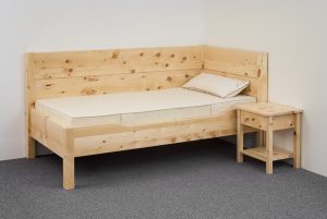 Einzelbett Traithen, massive Alpenzirbe, erhöhter Wandschutz, Kopfhaupt und Fußteil mit Aufsatzleiste, Seitenwange abgesenkt, Abb. optional: Zirbenholz-Nachtkästchen, ergonomisches ProNatura-Schlafsystem - Original Steiner Zirbenbett