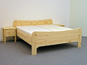 Doppelbett Wiesberg, Kopfhaupt und Fußwange mit nach innen geschwungenem Bogen, abgerundete Bettpfosten, Seitenwangen abgesenkt, Abb. mit optionalen Nachtkästchen und ergonomischem ProNatura-Schlafsystem - Original Steiner Zirbenbett