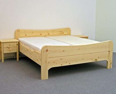 Doppelbett Wiesberg, Kopfhaupt und Fußwange mit nach innen geschwungenem Bogen, abgerundete Bettpfosten, Seitenwangen abgesenkt, Abb. mit optionalen Nachtkästchen und ergonomischem ProNatura-Schlafsystem - Original Steiner Zirbenbett