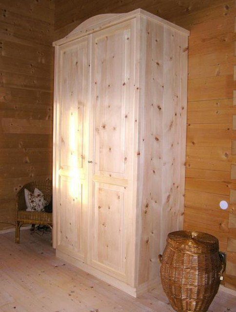 Zirbenholzschrank 3.1 mit geschweiftem Aufsatzgesims und Sockel, 2-türig, optisch zweigeteilte grifflose Türfronten mit erhabenen Füllungen, passt zum Zirbenschlafzimmer oder als Wohnmöbel