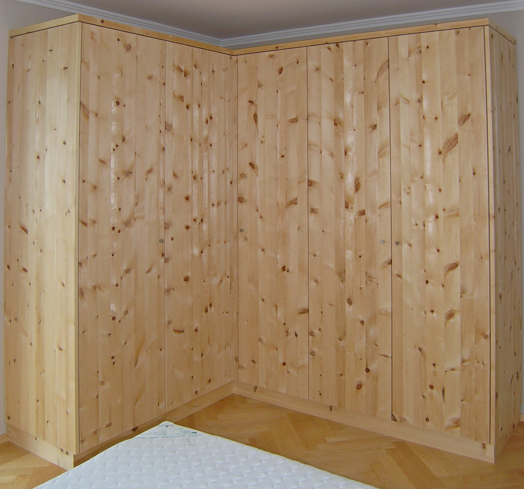 Zirbenholz-Kleiderschrank 09.1, eleganter Eckschrank aus massiver Zirbe, 6 glatte, grifflose Türen öffnen mit leichtem Druck, leicht zugängliches, großes Eckteil, passend zu Original Steiner Zirbenbetten