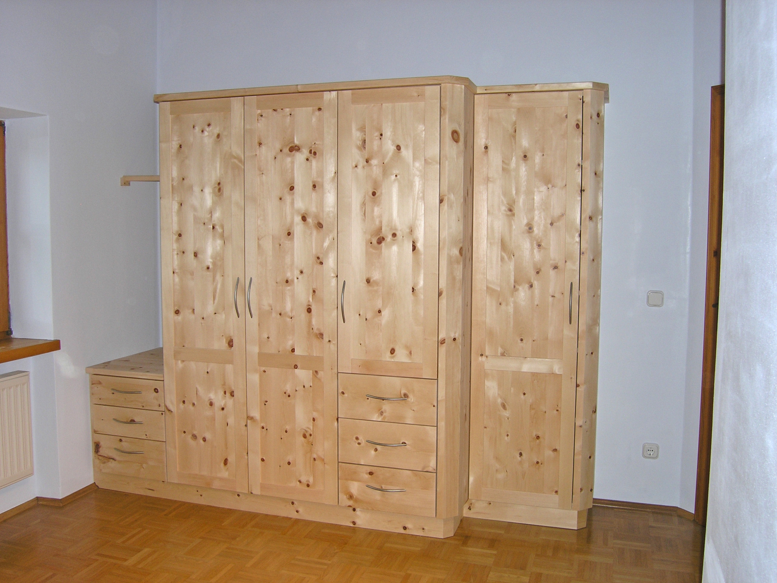 Zirbenholz-Kleiderschrank07.1, 5-teilig, 4 Türelemente und angebautes Schubladenelement, zurückgesetztes Türelement, geringere Tiefe, abgeschrägte Korpuskanten, Maßeinbau, passend zu Original Steiner Zirbenbetten