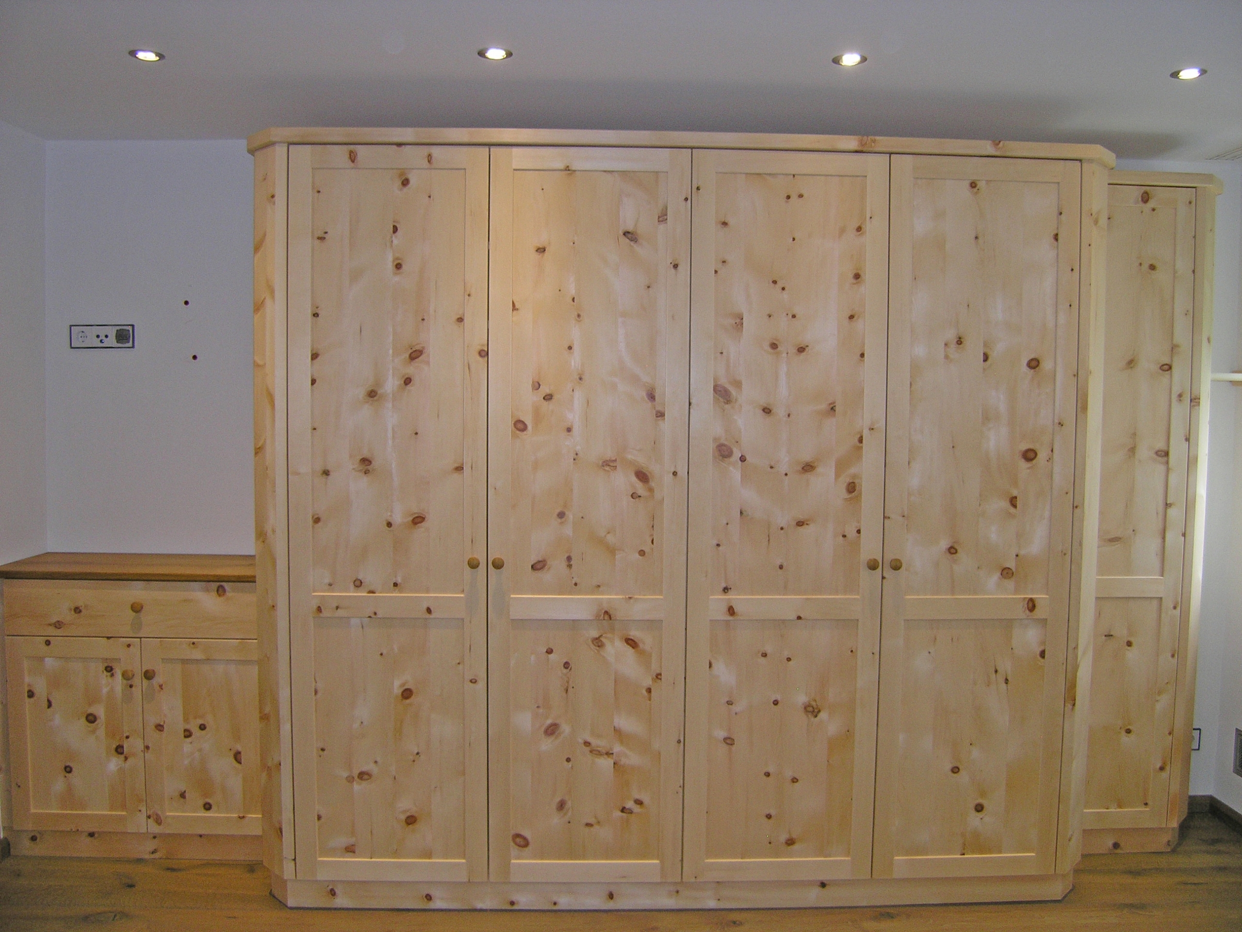 Zirbenholz-Kleiderschrank 07.2, massive Zirbe, Korpus mit abgeschrägten Kanten, 6-teilig, 5 hohe Türelemente, 1 zurückgesetztes Türelement, 2-geteilte Rahmentüren mit glatten Füllungen, angebaute Kommode mit Deckplatte aus Eiche, passend zu Original Steiner Zirbenbetten