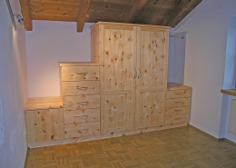 Zirbenholz-Kleiderschrank 10.4, massive Zirbe, Besonderheit, 2-türiger Schrank, angebaute Kommoden-Elemente, unterschiedlich hoch, 9 Schubladen, 2-geteilte Türfronten mit abgeplatteten Füllungen, Aluminium-Bügelgriffe, passend zu Original Steiner Zirbenbetten